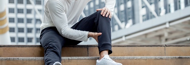 fitness man have knee pain sitting on steps of stair in the city. sport injury leg of run in urban , accident , exercise,workout